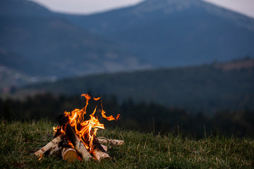 burning bonfire in the evening in the carpathian mountains. place for inscription