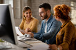 © Drazen - Group of young business colleagues analyzing reports in the office.
