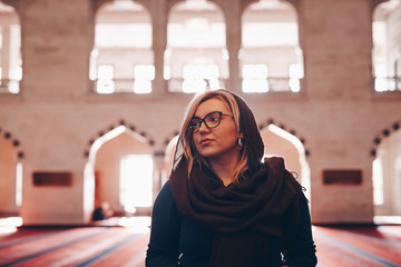 Wall Mural - portrait of a beautiful blonde tourist woman visiting kocatepe mosque in ankara, turkey. concept of travelling and experiencing new religions and cultures