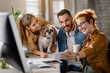 © Drazen - Young happy entrepreneurs with a dog photo messaging on a break in the office.
