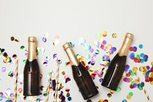 Composition With Mini Champagne Bottles And Glitter On White Background, Copy Space