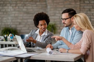 Wall Mural - African American financial advisor and a couple using laptop during the meeting.