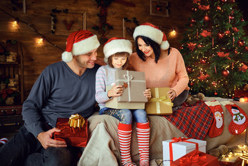 Family gives daughter a gift in the room at Christmas.