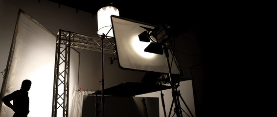 Wall Mural - Silhoutte images of video production and lighting set for filming which movie crew team working and silhouette shadow of camera and professional equipment in big studio for commercial advertising.