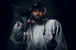 © Fxquadro - Professional hockey player in helmet is posing with hockey stick at photo studio.
