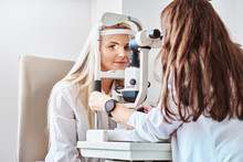 Attractive Woman Is Doing Eye Test In Optical Clinic With Experienced Oculist.