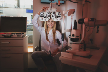 Wall Mural - Beautiful smiling woman is posing for photographer at oculist cabinet.