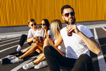 A group of young friends having fun and hanging out sitting in the city on the asphalt