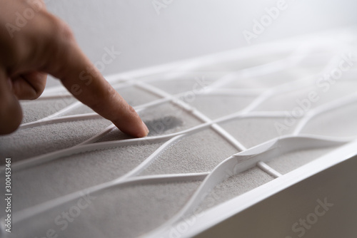 Fotografía Soft focus of man hand touching the very dirty air conditioner filter with a lot of dust