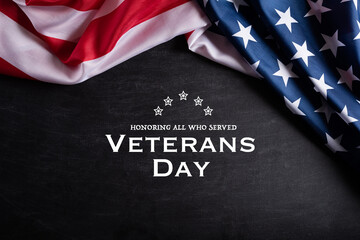 Happy Veterans Day. American flags with the text thank you veterans against a blackboard background. November 11.