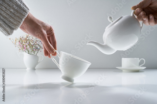 Fotografía Composition with white porcelain tea-ware on a light gray background with a deli