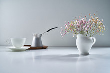 Composition With White Porcelain Tea-ware On A Light Gray Background With A Delicate Bouquet Of Flowers