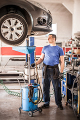 Wall Mural - Mechanic discharges motor oil from engine tank under the car