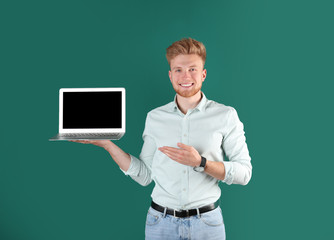 Wall Mural - Happy man with laptop on green background. Space for text