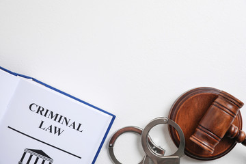 Wall Mural - Book with words CRIMINAL LAW, handcuffs and gavel on white background, flat lay. Space for text