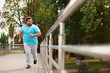 © New Africa - Young overweight man running outdoors. Fitness lifestyle