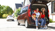 © New Africa - Happy family sitting in car trunk outdoors. Moving day