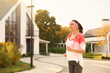 Sticker - Beautiful sporty woman running on street. Healthy lifestyle