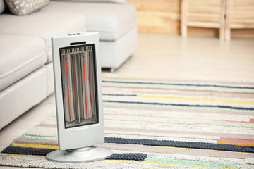 Sticker - Modern electric infrared heater on floor at home. Space for text