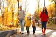 © New Africa - Happy family with little daughters walking in autumn park