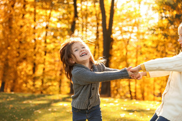 Wall Mural - Happy little girls playing in sunny park. Autumn walk