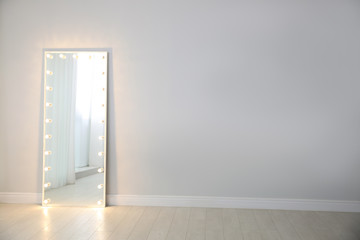 Wall Mural - Large mirror with light bulbs near light wall indoors. Interior element