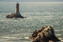 Concrete Lighthouse On A Rock Formation In The Middle Of The Sea