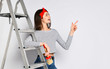 Young brunette girl with a brush and ladder - indicates a space for your advertising.