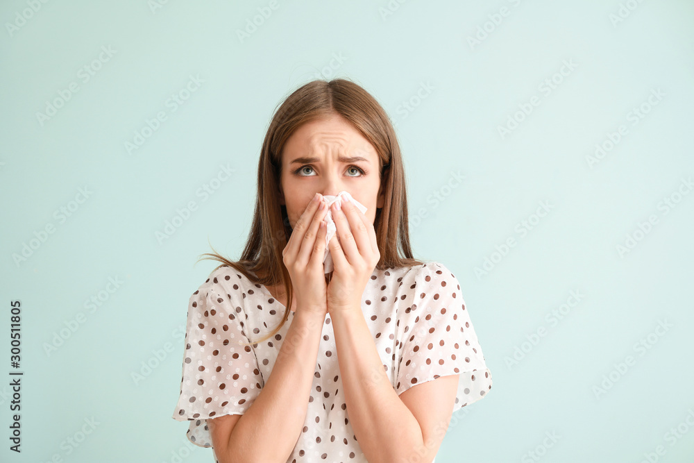 Young woman suffering from allergy on light background - obrazy, fototapety, plakaty 
