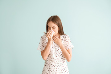 Wall Mural - Young woman suffering from allergy on light background