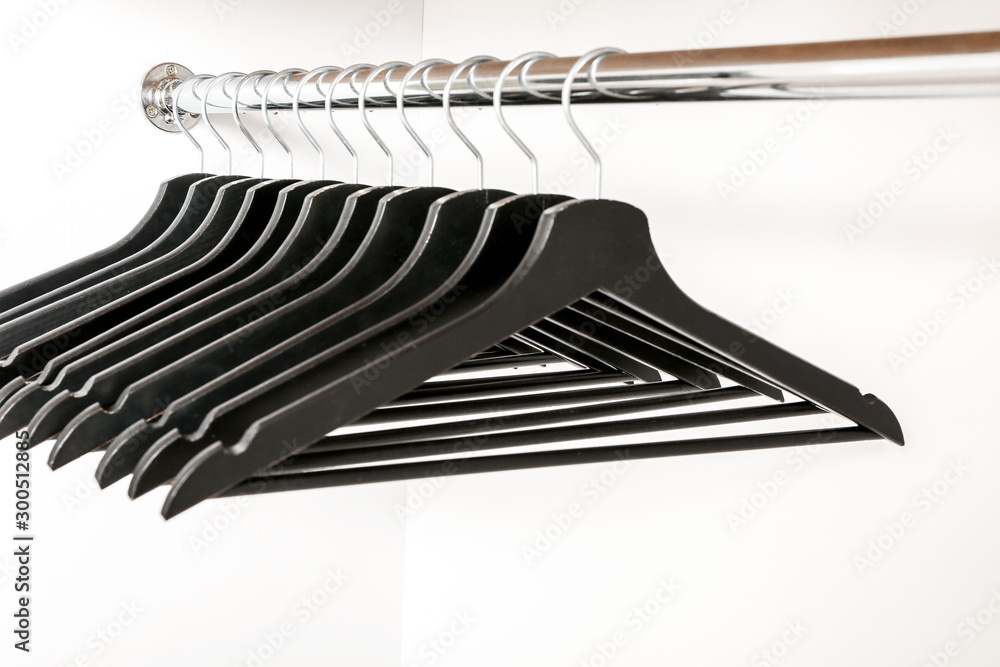 Rack with clothes hangers on white background