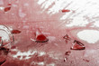 © igorgeiger - Shattered glass from a broken glass on a tablecloth drenched in red wine.