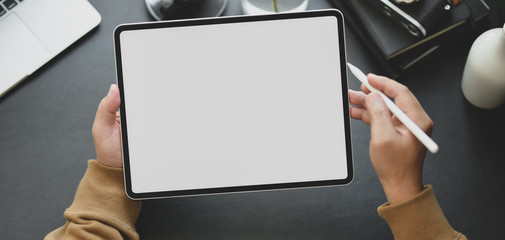 Canvas Print - close-up view of man using blank screen tablet while working in dark modern workplace