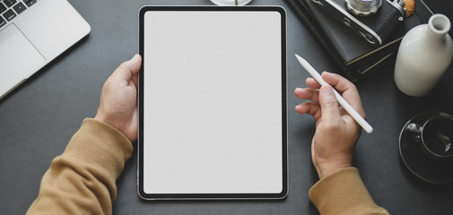 Canvas Print - close-up view of man using blank screen tablet while working in dark modern workplace