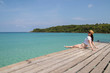 © allenkayaa - Young woman in a hat sits on a pier near the clear turquoise sea