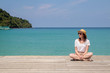 © allenkayaa - Young woman in a hat sits on a pier near the clear turquoise sea