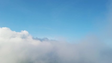 Wall Mural - Flying through the clouds above mountain tops. Mountains wonderful evening sunset natural Landscape.