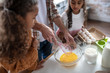 © zinkevych - Girls watching their father whipping eggs while cooking pie