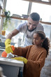 © zinkevych - Daddy smiling while cute daughter cleaning kitchen