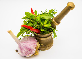 Mortar with fresh herbs and hot red pepper