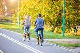 Fototapeta  - Cyclists ride on the bike path in the city Park