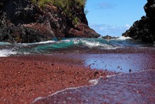 Up Close View A Aquamarine Waves Rolling Onto Red Sand Beach On Kaihalulu Beach, Hana, Maui, Hawaii.