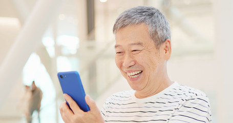 elder man use smart phone