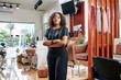 Confident attractive young Black woman standing in her beauty salon with arms folded and looking at camera