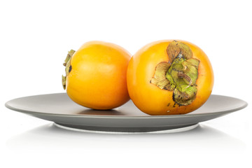 Wall Mural - Group of two whole sweet orange persimmon on gray ceramic plate isolated on white background