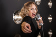 Image of glamour artist woman in elegant dress singing into microphone