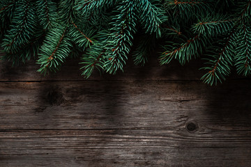 Wall Mural - Christmas green frame from fir branches on a vintage gray board background. Frame of fir branches. Christmas card blank.