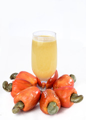 Cashew nuts isolated with glass of fruit juice on white background