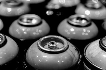 Spraycans with black and white theme lined up together on a table..Paint, art, pattern, texture, retro, graffiti, aerosol, urban, street, city concept.