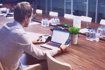 Male hand,  IP phone and laptop on the office table. Ip telephony and video meetings for business concept. Close up.